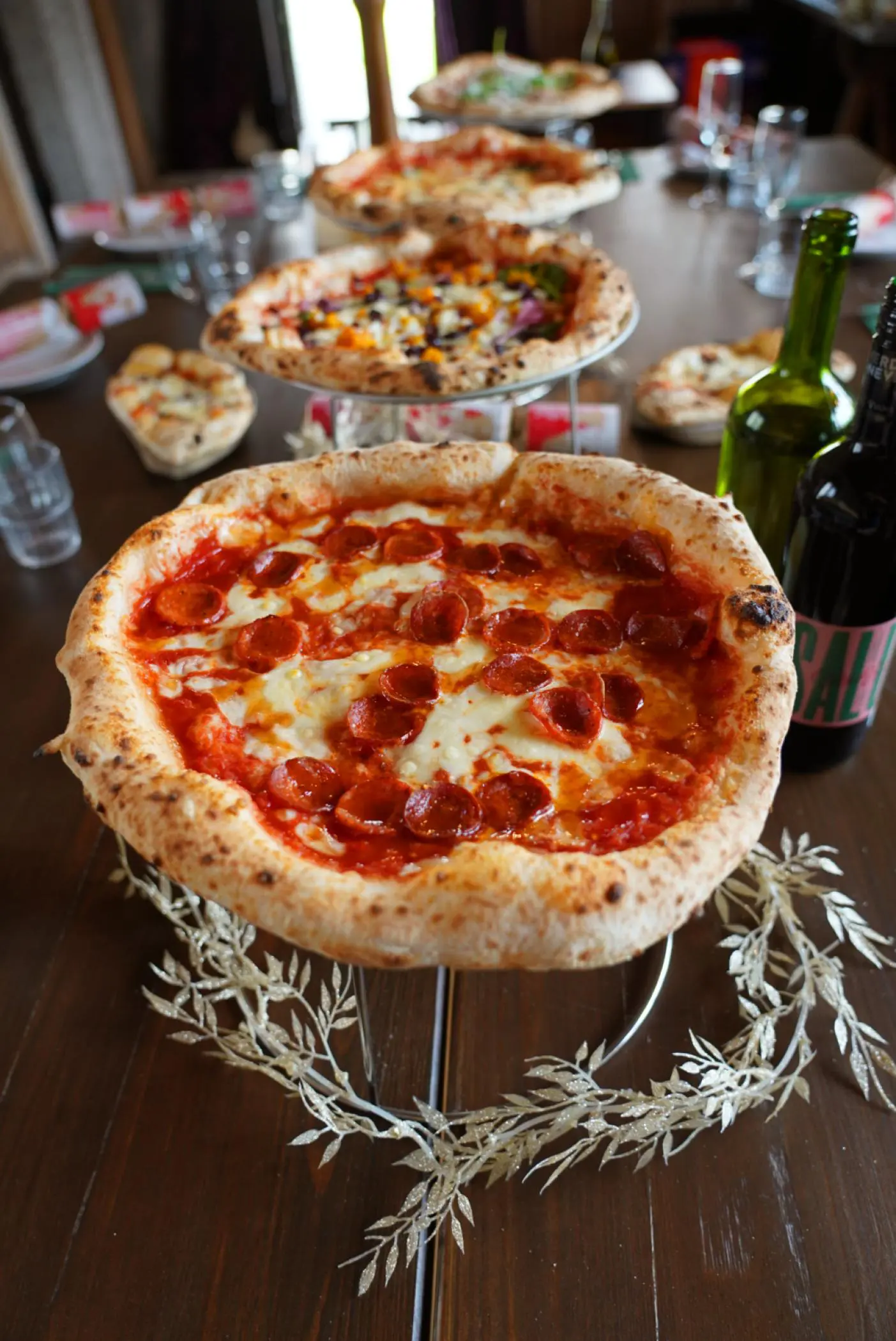 A long table laid with pizzas on stands